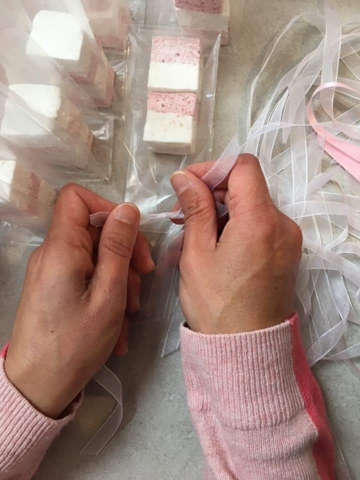 Handcrafted marshmallow wedding favours tied with ribbon at a celebration table